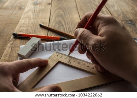 the men is makins a drawing on wooden background