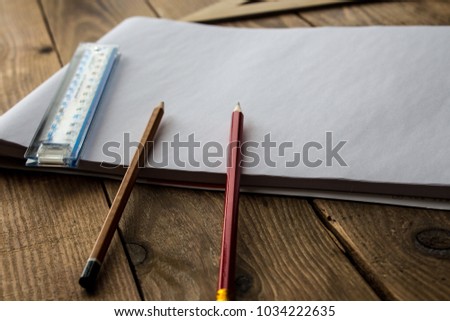 pencils and ruler near white sheet of paper