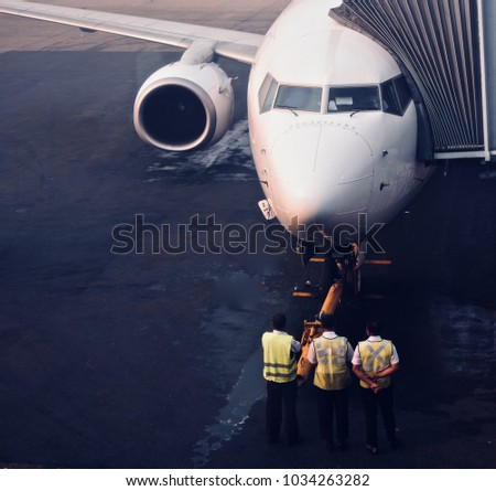 Ground staff people are inspecting to prepare the airplane to fly stock photograph