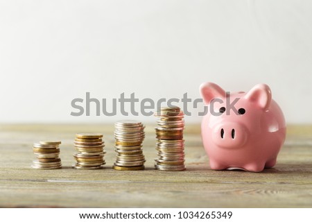 piggy bank with coin on old wooden table