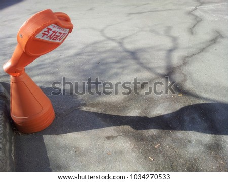 Broken neck cone with shadow on road, Broken NO PARKING cone traffic cone with No-parking sign in Korean letters