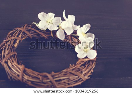 Wreath with spring flowers on a dark wooden background.  Flowering of the apple tree.