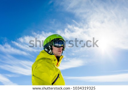 Photo of sporty man wearing mask and helmet against blue sky