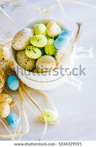 Table setting for Easter dinner with eggs on white wooden table
