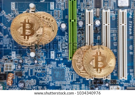 a gold coin with the symbol of bitcoin lies on a circuit board