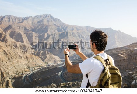 Man taking picture of the Jabal Jais mountain range view