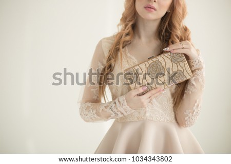 beautiful blonde girl holding a handbag in her hands, horizontal photo, free space, on a white background