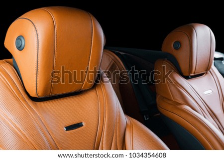 Modern Luxury car inside. Interior of prestige modern car. Comfortable leather red seats. Brown perforated leather cockpit with isolated Black background. Modern car interior details