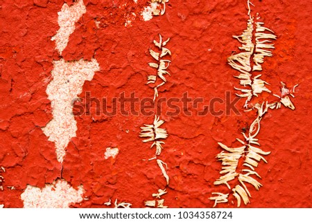 Old red scratched oil paint covered wall, close-up photo. Vintage grunge colored retro background. Abstract textured pattern..