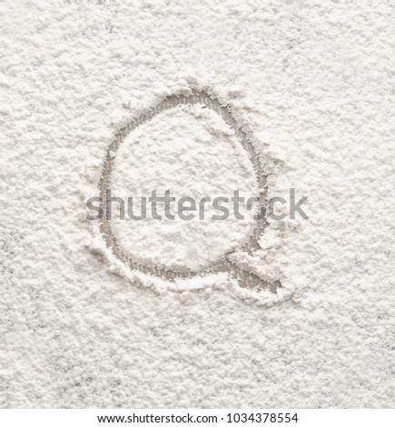 Letter Q written on flour