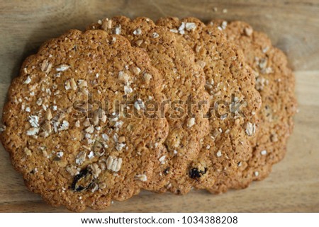 Round brown granola whole wheat oat cookies with raisin on wooden background
