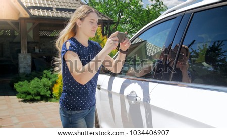Portrait of woman taking photos of car for insurance company