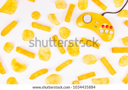 Yellow joystick and potato chips. Harmful food and gamepad. GamePad.