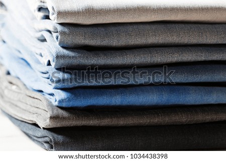 Stack of jeans in different colors.
