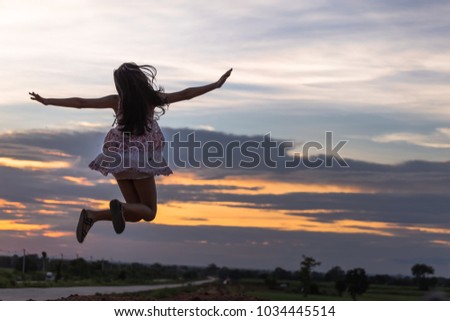 Beautiful asian woman standing on the 
mound with sunset