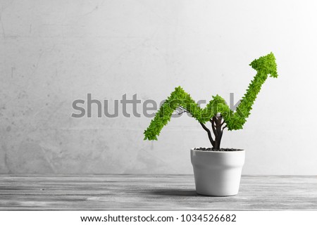 Small plant in pot shaped like growing graph Royalty-Free Stock Photo #1034526682