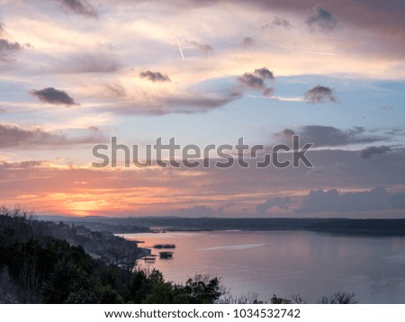 High Resolution Picture of Sun setting behind Hills with Lake in the Foreground