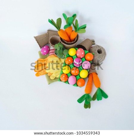 Easter holiday. Easter eggs and carrots. Knitted carrot. For planting tools. Garden gloves.