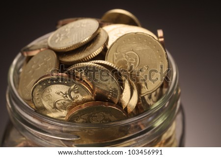 Close up Coins in overflowing jar