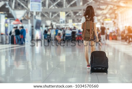 Asian teenage girl is using a smartphone to check flight at the international airport to travel on weekends. Royalty-Free Stock Photo #1034570560