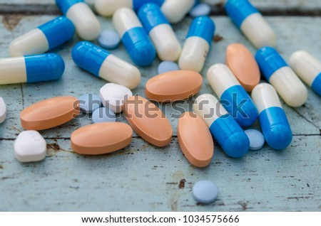 Tablets and capsules on the wooden floor.