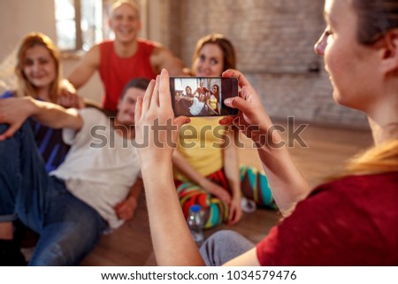 Girl taking picture of smiling modern dancer friends