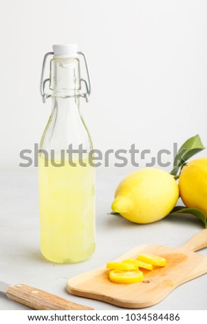 lemonade on a light background. summer traditional Italian home-made drink from Sicilian lemons. a drink of yellow color. articles made of fruits. old background with a picture of a drink in a bottle