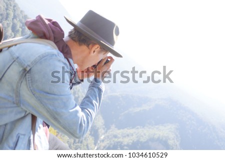 Explorer young man takes pictures with photo camera outdoor.