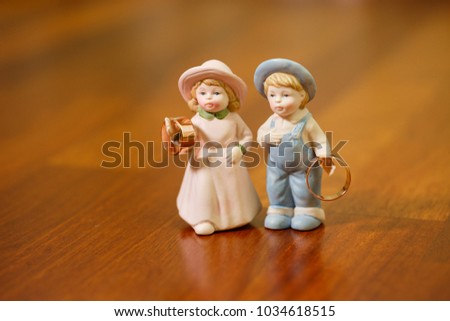 Wedding rings with statues of the bride and groom
