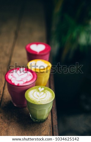 Trendy multicolored lattes. Beetroot, avocado and turmeric tastes with latte art.