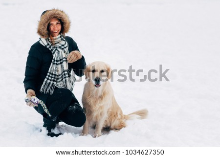Photo of smiling girl with dog in winter park