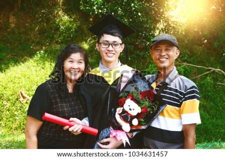 student and family celebrating graduation outdoor Royalty-Free Stock Photo #1034631457