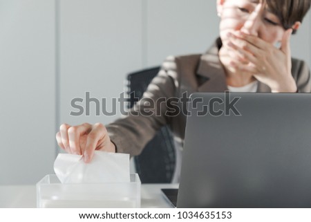 Young asian woman blowing her nose. Nasal inflammation. Hay fever. Royalty-Free Stock Photo #1034635153