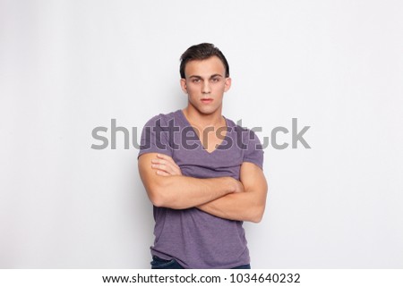 emotion, advertisement and people concept - Handsome young man on grey background looking at camera. Portrait of laughing young man in pockets leaning against grey wall. Happy guy smiling.