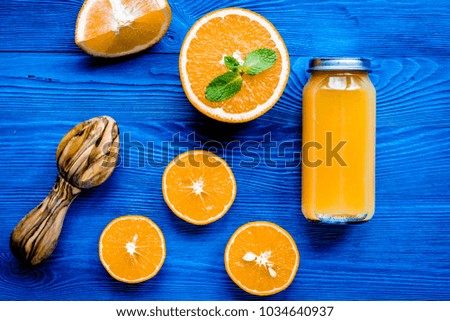 Orange juice in bottle with slices and mint on table top view