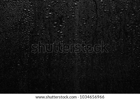 Part of series. Background photo of rain drops on dark glass, different size: small medium and large horizontal view Royalty-Free Stock Photo #1034656966
