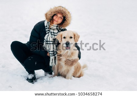 Picture of smiling girl with labrador in winter park