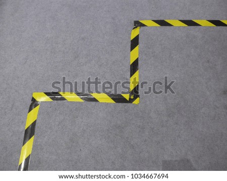 Warning ,caution tape yellow and black on grey background with copy space