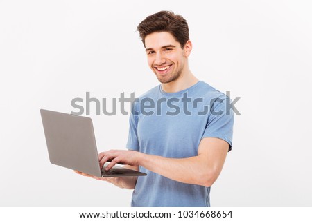 Picture of handsome man in casual t-shirt holding silver notebook and chatting or working isolated over white background