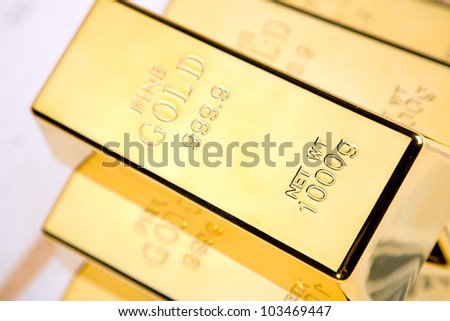 Photo of gold bars on graphs and statistics, studio shots, closeup