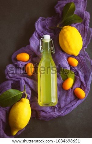 lemonade on a dark background. summer traditional Italian home-made drink from Sicilian lemons. products from fruit in a low key. old background with a picture of a drink in a bottle with a purple fab