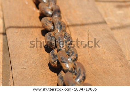 Metal Anchor chain on a teak deck of a classic sail boat in the baltic sea