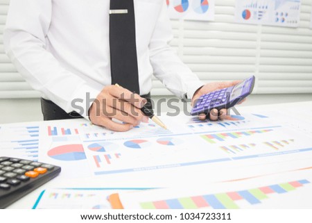 Businessmen are calculating and analyzing performance statistics for future investments.