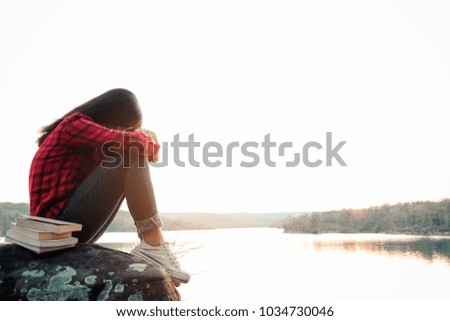 Relaxing moments, Young woman reading a book by the lake. Solo relaxation, color of Hipster Tone.