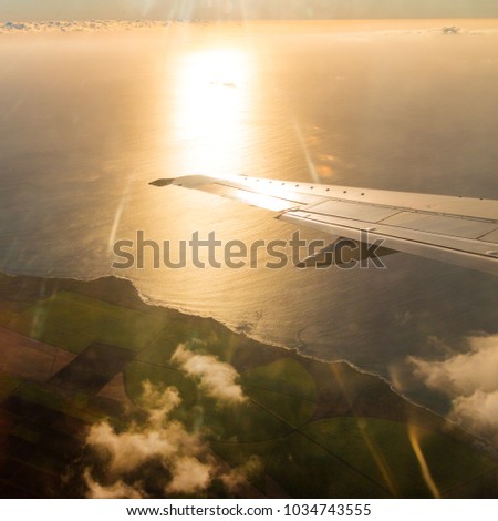 Last sunrays over Indian ocean. Romantic sunset on Reunion Island coast near Saint Denis from airliner. 