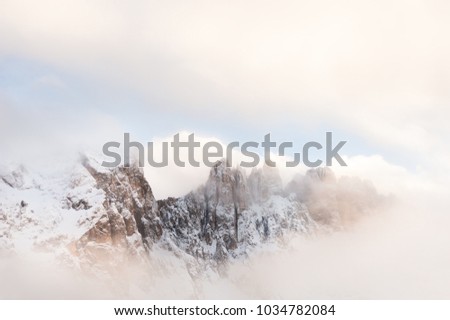 Mountain peaks in the clouds. Winter landscape in Dolomites, Italy
