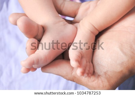 Love pictures, tenderness Father Hand and Baby Feet