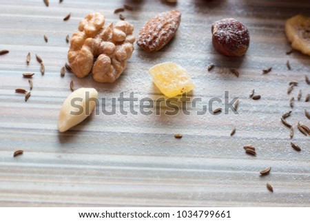 mix nuts and candied fruits on a striped table sprinkled with powdered sugar