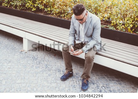 Serious Businessman Using Smartphone in Park