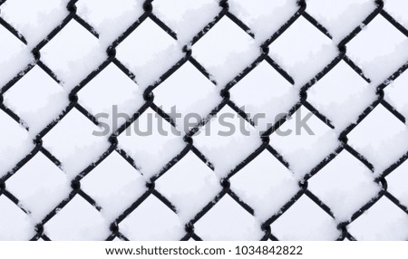 Metal wired fence under a snow - texture background
